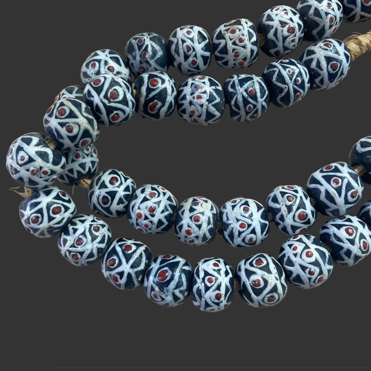 Decorative beads with intricate patterns on a light wooden surface